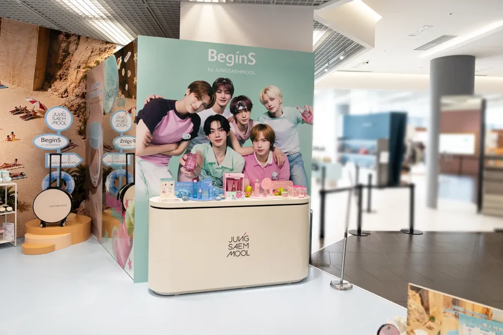 「JUNGSAEMMOOL」のロゴが入った商品展示カウンター。背面に設置された「TWS」の大型パネルと、天板上にディスプレイされたコスメアイテムの様子。