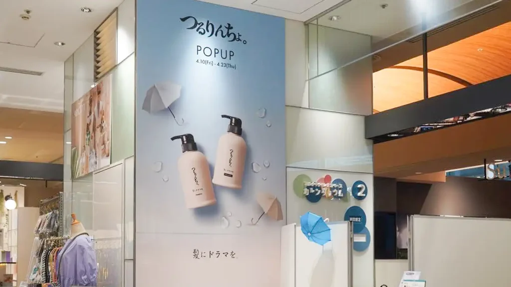 case_kaminidoramawo-03_09 | 株式会社ビーツ(BEEATS) Storefront poster advertising POPUP beauty products with two white pump bottles on a blue background in a mall display.